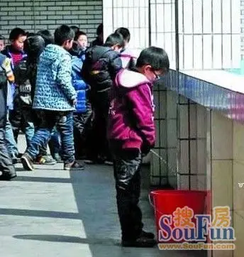 浙江东阳一小学走廊上放着许多用来接童子尿的水桶,这个水桶是