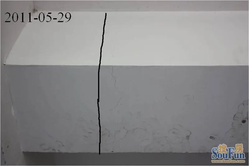 这是房子大梁上出现的贯穿性裂缝,虽然很细,但证明了大梁已断裂.